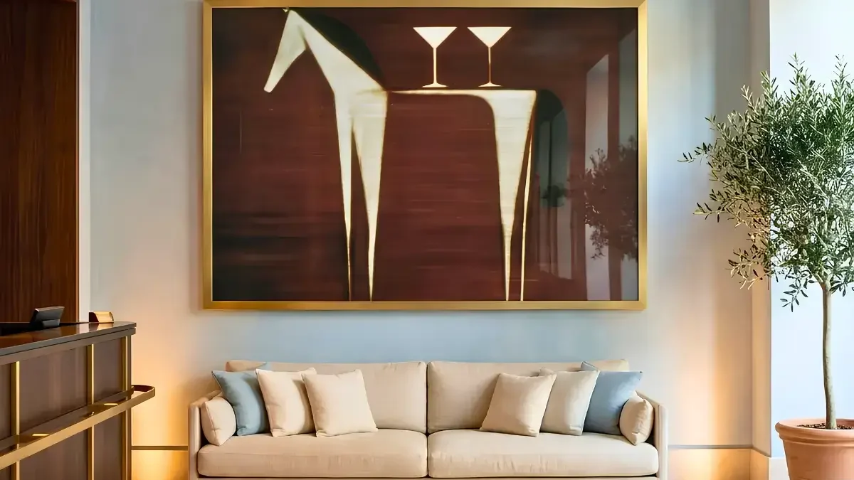 A large painting of a horse hangs above a couch in a stylish interior, showcasing art consultancy by interioritalia.