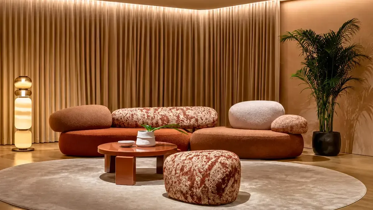 A stylish living room featuring a round couch and two matching ottomans, showcasing bespoke Italian furniture by Interioritalia.