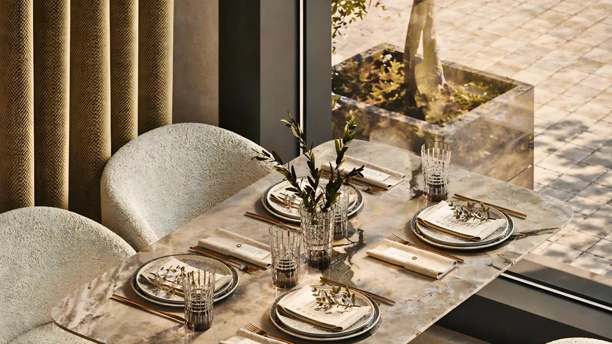 A modern dining table is elegantly set for four, featuring a foliage centerpiece. Curved, textured chairs by large windows complete the look—an inviting f&b interior fit-out by interioritalia.